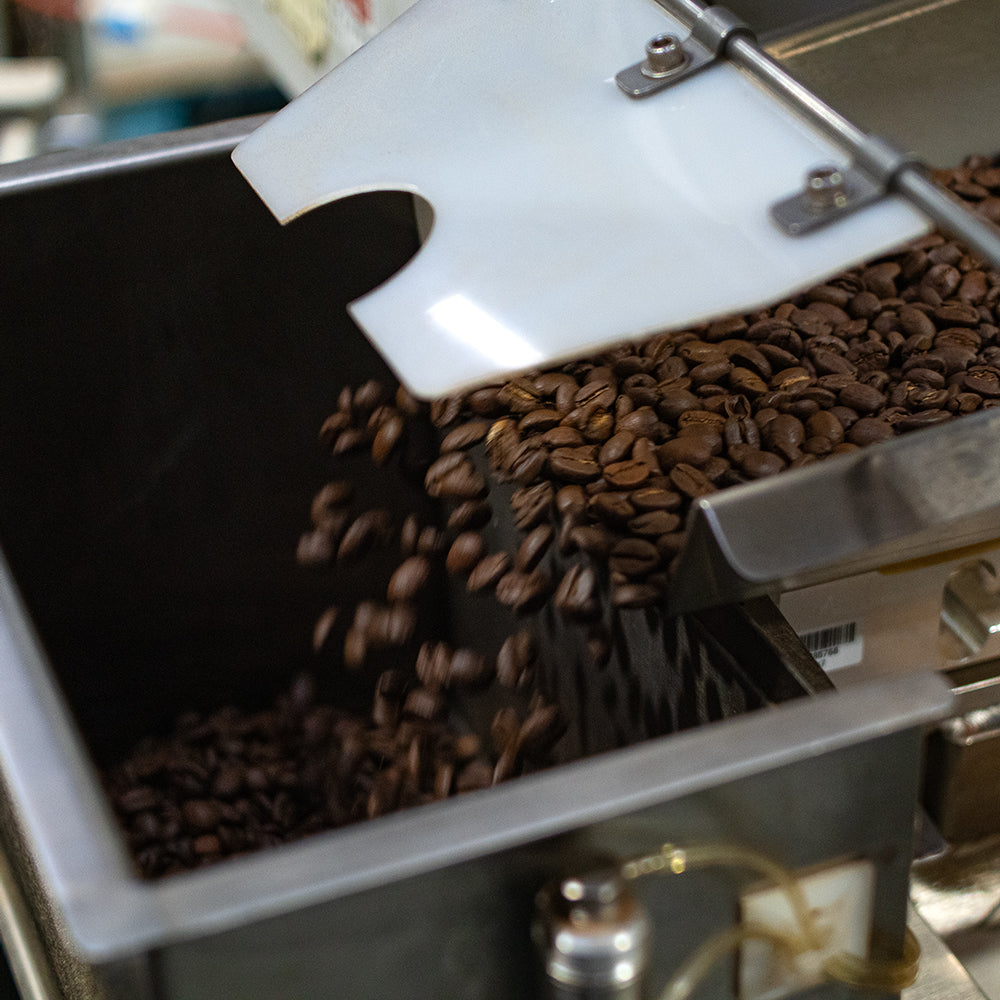 Coffee being portioned out in a machine for packing.